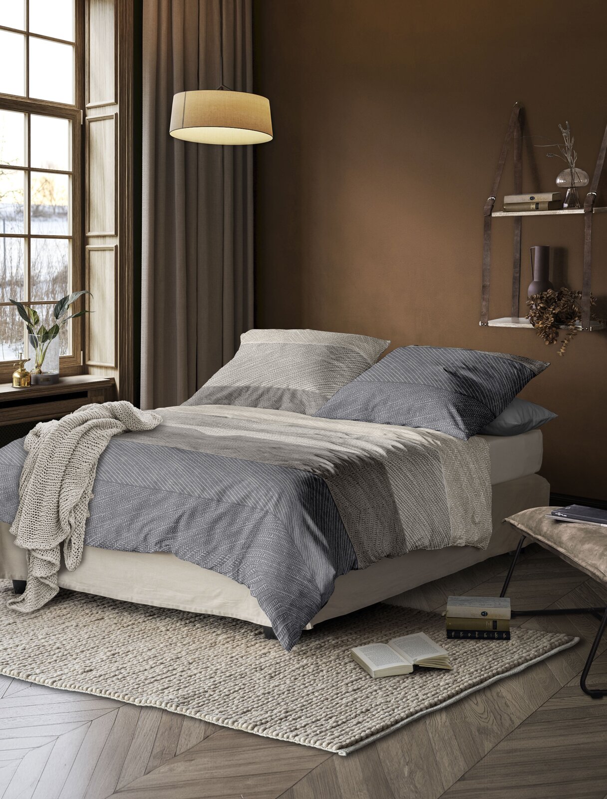 Gemütliches Schlafzimmer mit Bettwäsche in Grau- und Beigetönen, seitliche Perspektive