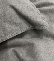 Nahaufnahme von grauer Bettwäsche mit sichtbaren Nähten und Textur