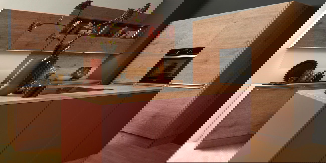 Die Küche hat Schränke aus Holz und eine rote Kochinsel