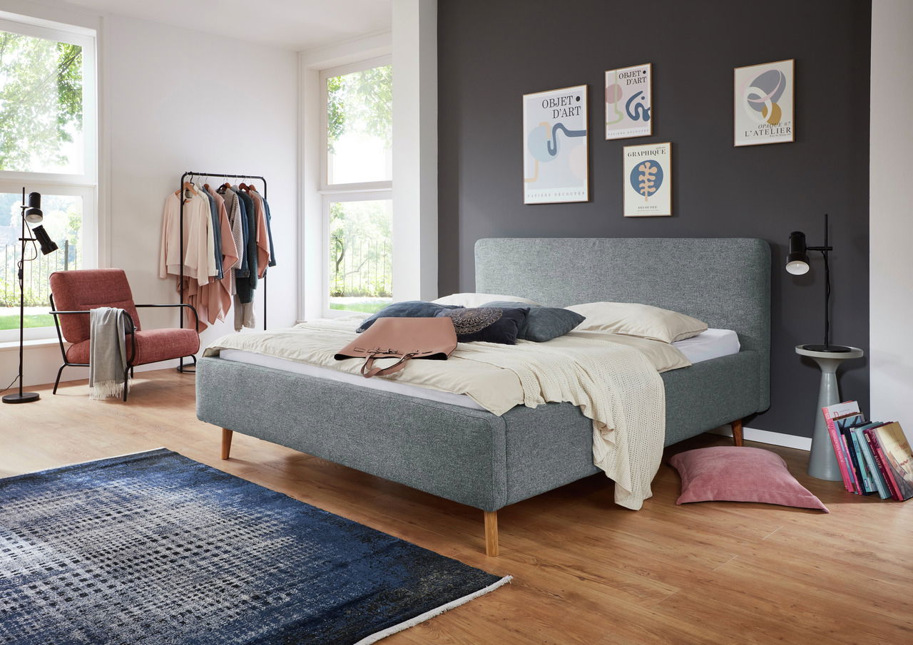 Modernes Polsterbettgestell in einem stilvoll eingerichteten Schlafzimmer, seitliche Perspektive.