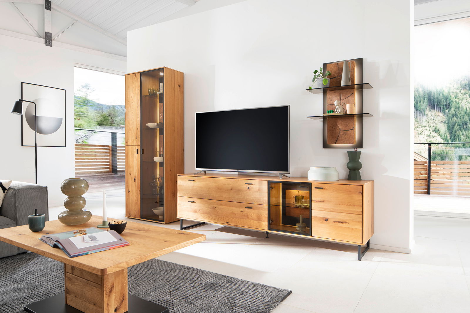 Moderne Wohnzimmer-Wandkombination aus Holz mit TV-Schrank, Vitrine und Wandregal, seitliche Perspektive.