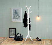 Weißer Garderobenständer mit mehreren Haken, frontal fotografiert, in einem stilvoll eingerichteten Raum mit Holzboden, Wandbildern und einer Hängelampe.