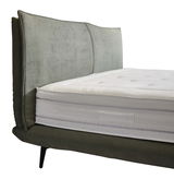 Seitliche Ansicht eines Boxspringbetts mit gepolstertem Kopfteil und weißer Matratze.