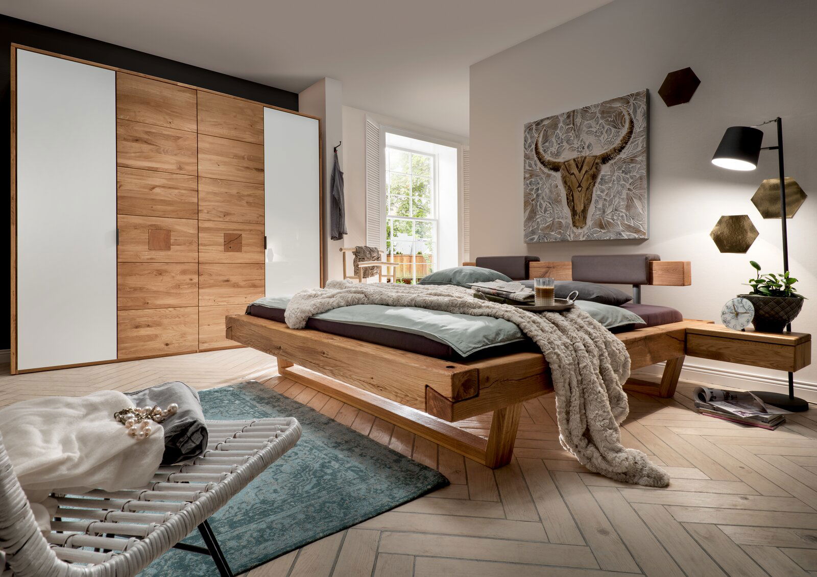 Moderner Kleiderschrank mit vier Türen in Holzoptik und weißen Elementen, seitliche Perspektive im stilvollen Schlafzimmer.