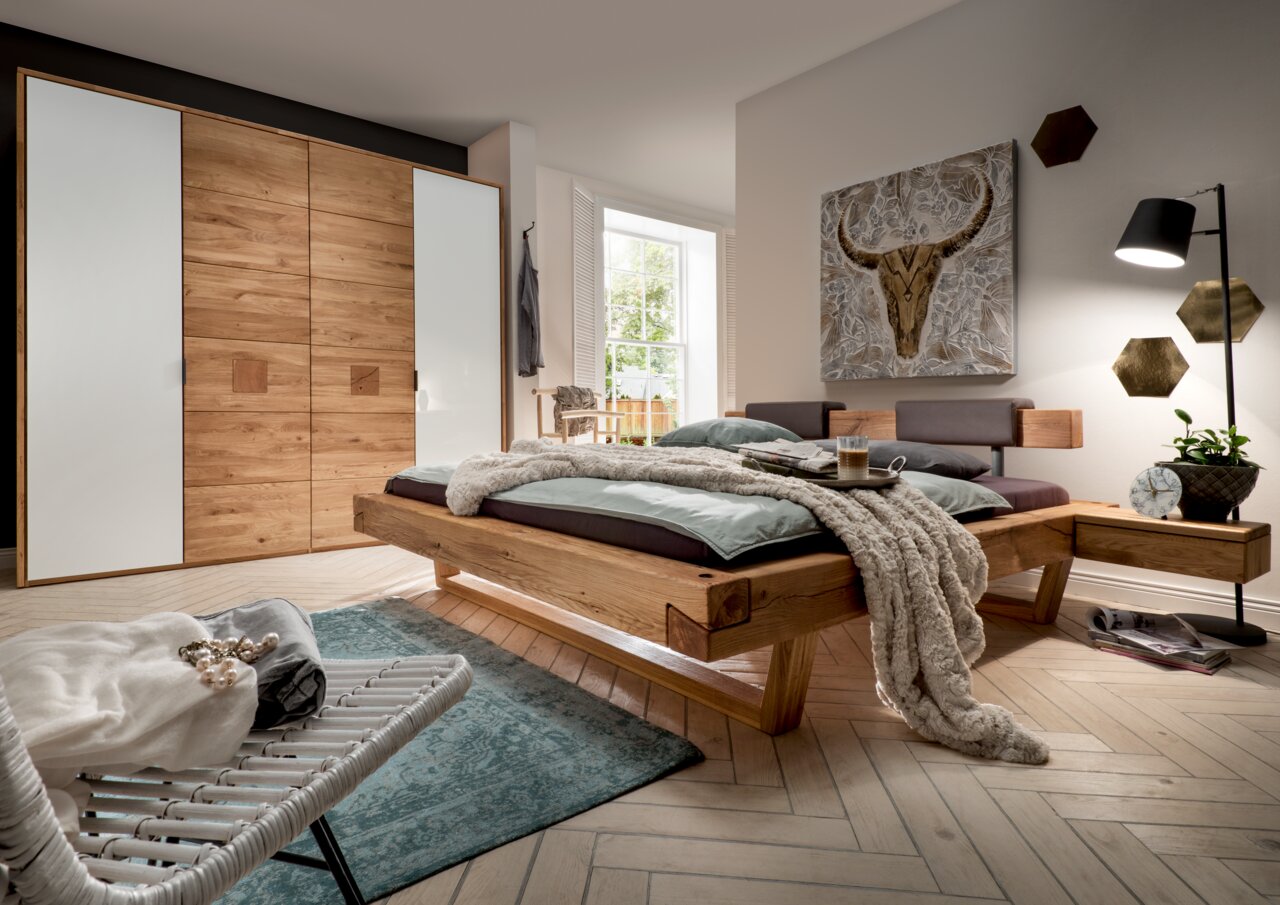 Valnatura Kleiderschrank 4-türig LIGNUM Moderner Kleiderschrank mit vier Türen in Holzoptik und weißen Elementen, seitliche Perspektive im stilvollen Schlafzimmer.