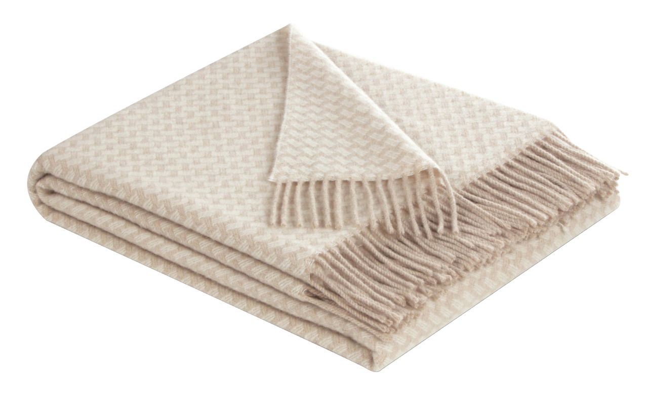 Beige karierte Decke mit Fransen, gefaltet und aus einer schrägen Perspektive fotografiert.