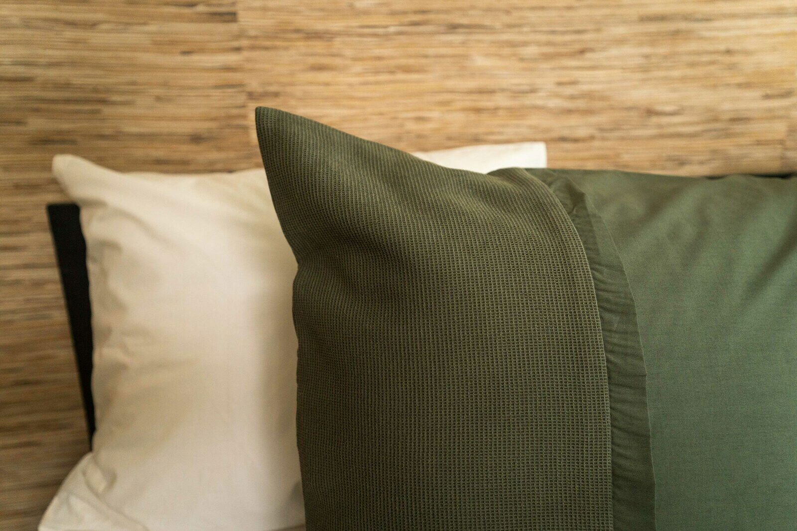 Nahaufnahme einer Bettwäsche in Olivgrün mit strukturiertem Muster, seitliche Perspektive