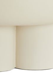 Nahaufnahme eines cremefarbenen Couchtischs mit abgerundeten Kanten, seitliche Perspektive.