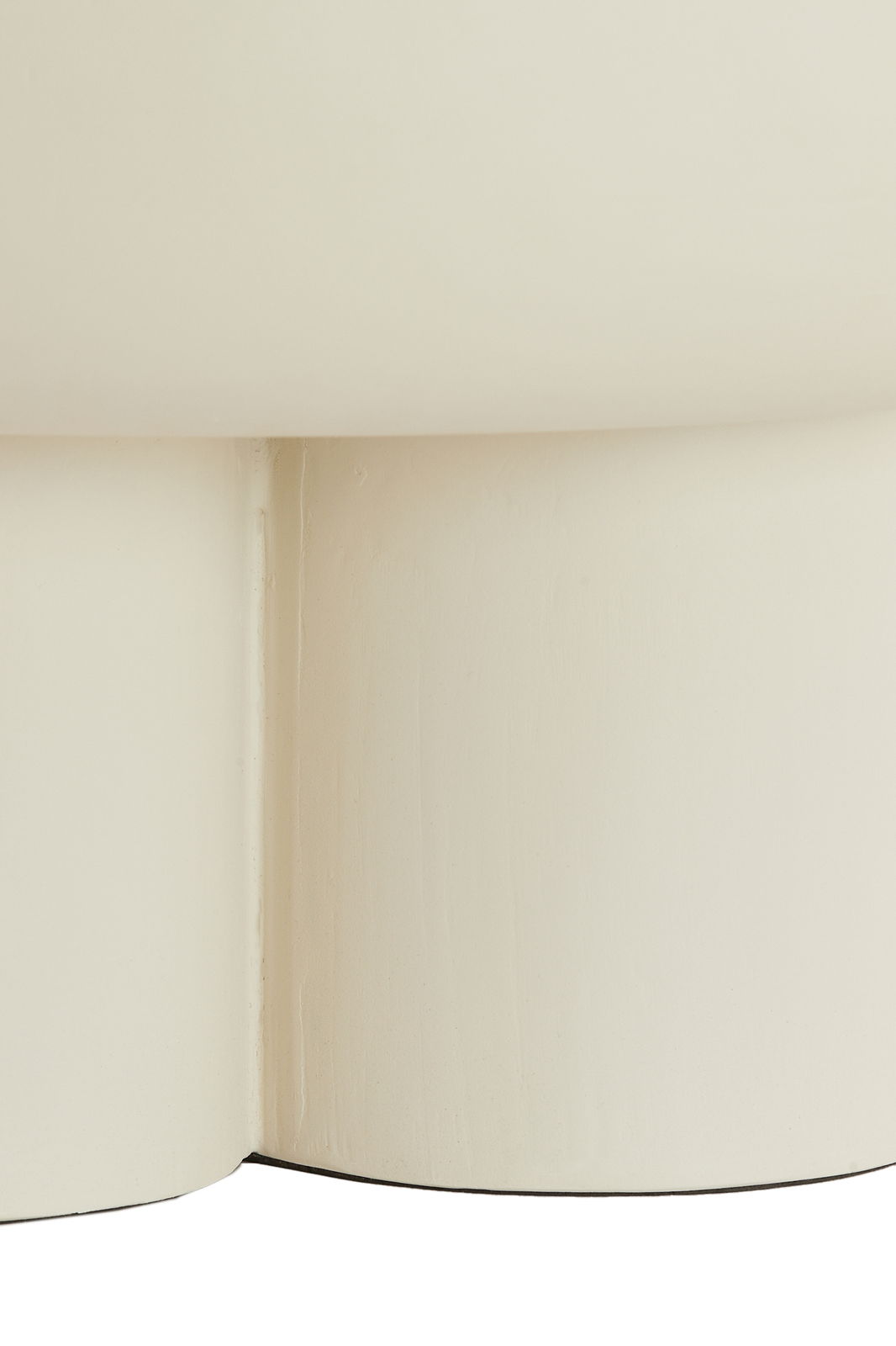 Nahaufnahme eines cremefarbenen Couchtischs mit abgerundeten Kanten, seitliche Perspektive.