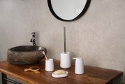 Modernes Badezimmer-Accessoire-Set in Weiß auf Holzwaschtisch neben Steinwaschbecken und rundem Spiegel, Frontansicht in leichter Schrägperspektive von oben