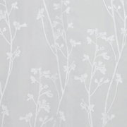 Nahaufnahme eines weißen Schlaufenschals mit floralen Mustern auf transparentem Stoff.