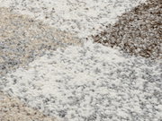 Nahaufnahme eines Frisé-Teppichs mit einem Muster aus cremeweißen, grauen und beigen Tönen.