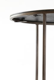 Nahaufnahme eines Couchtischs mit Metallrahmen und runder Tischplatte, seitliche Perspektive.