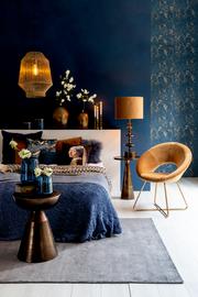 Beistelltisch aus Metall in einem stilvoll eingerichteten Schlafzimmer, seitliche Perspektive