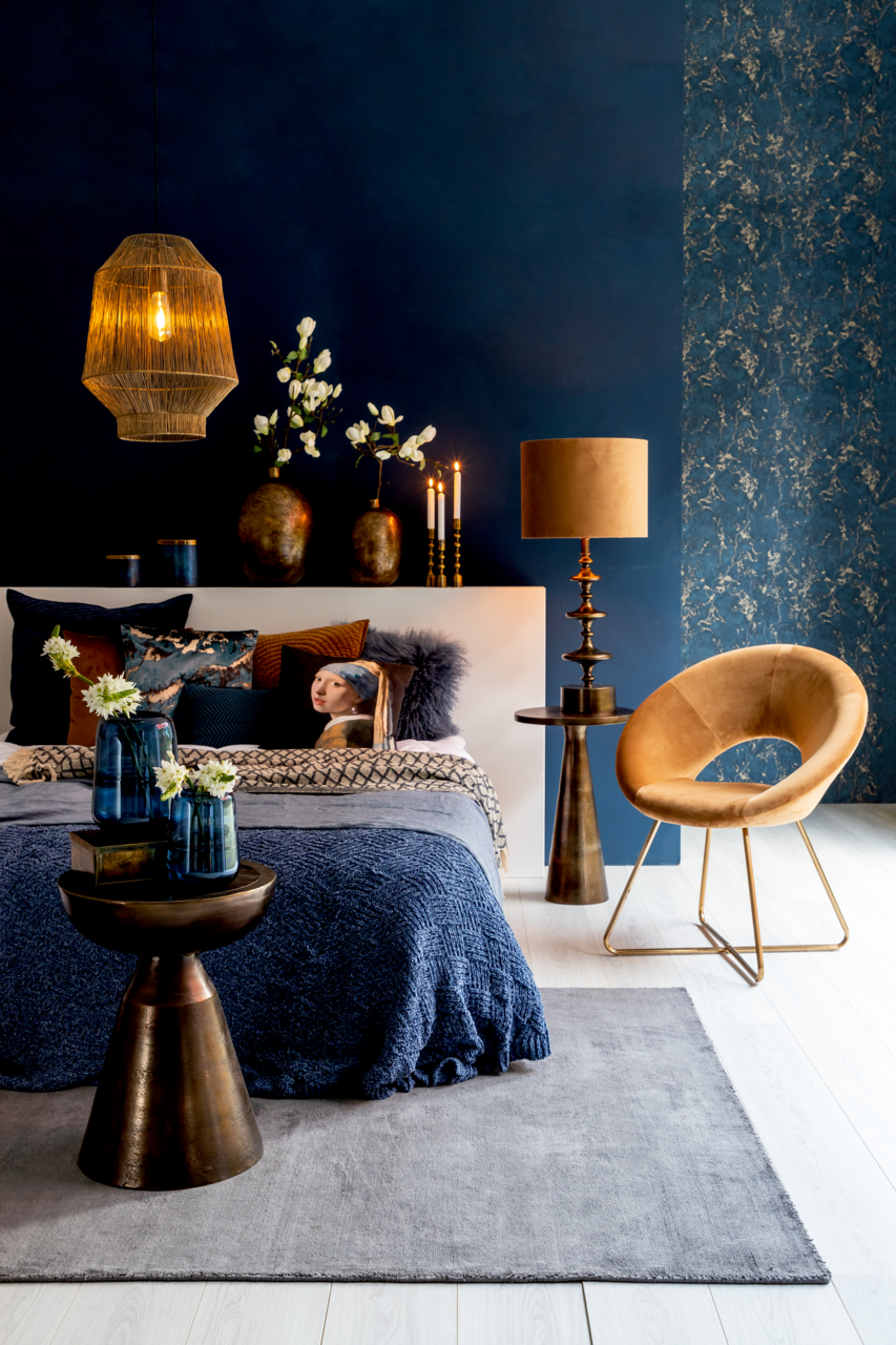 Beistelltisch aus Metall in einem stilvoll eingerichteten Schlafzimmer, seitliche Perspektive