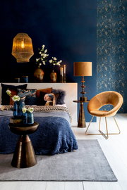 Beistelltisch aus Metall in einem stilvoll eingerichteten Schlafzimmer, seitliche Perspektive