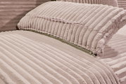 Nahaufnahme eines Funktionssofas mit weichem, geripptem Stoffbezug in Beige, Perspektive von der Seite.