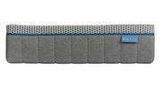 Seitenansicht einer grauen Matratze mit weißem, gemustertem Oberteil und einem blauen Etikett.