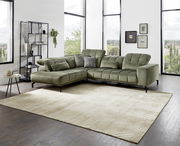 Grüne Eckgarnitur in modernem Wohnzimmer mit großen Fenstern, seitliche Perspektive