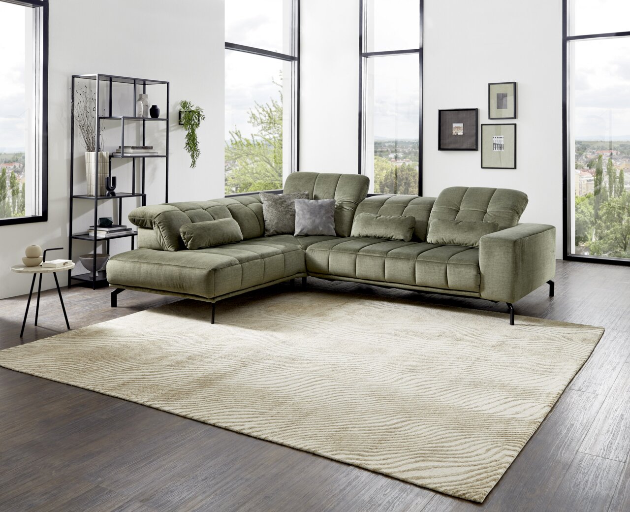 Grüne Eckgarnitur in modernem Wohnzimmer mit großen Fenstern, seitliche Perspektive