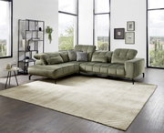 Grüne Eckgarnitur in modernem Wohnzimmer mit großen Fenstern, seitliche Perspektive