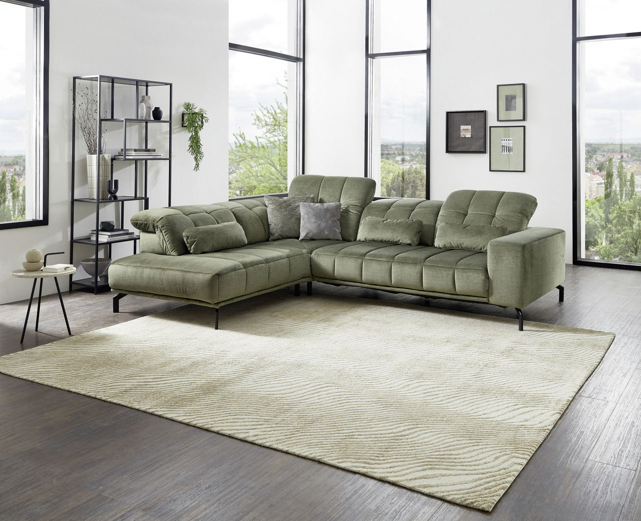 Grüne Eckgarnitur in modernem Wohnzimmer mit großen Fenstern, seitliche Perspektive