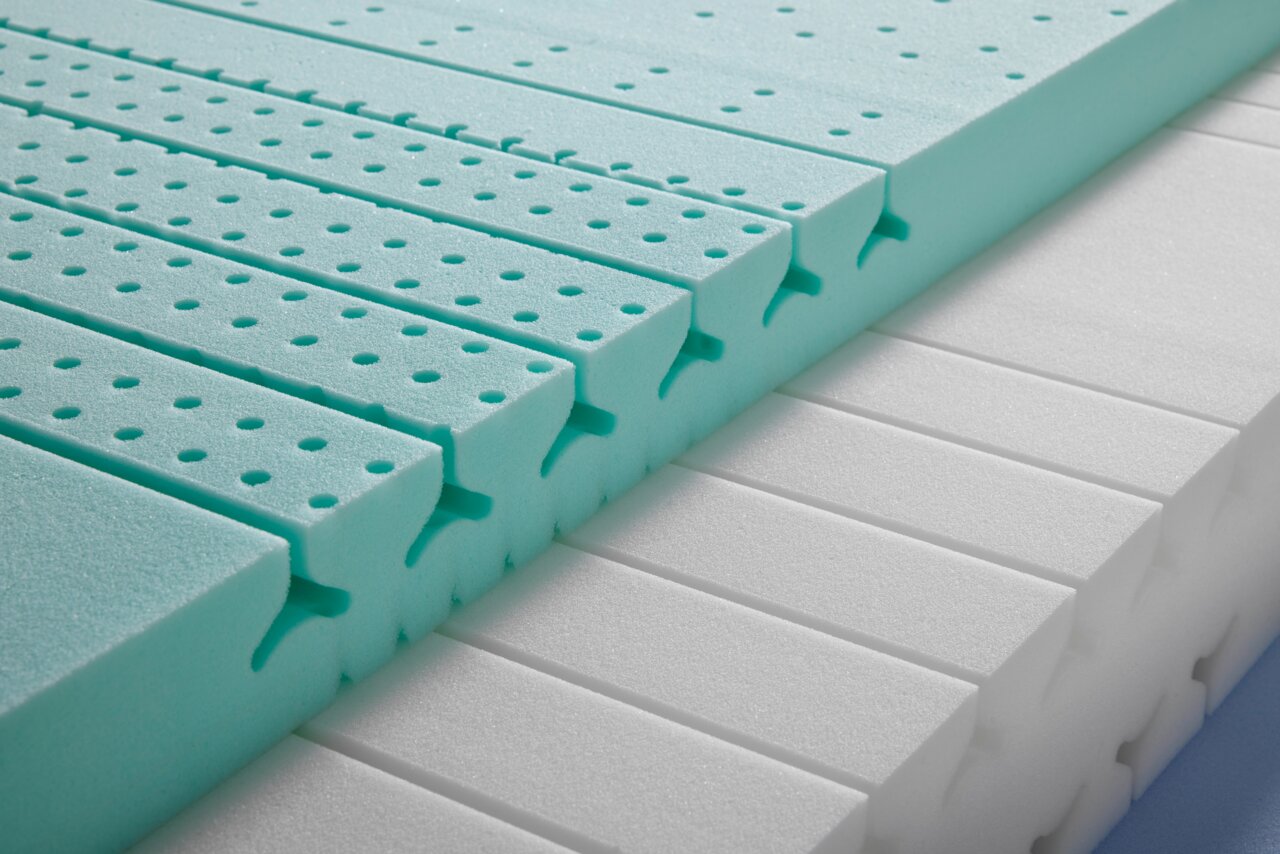 Nahaufnahme einer Wendematratze aus Kaltschaum mit grüner und weißer Schicht, seitliche Perspektive