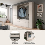 Moderne Garderoben-Schrankkombination in hellem Beige mit Kleiderstange, offenen Ablagefächern und Schubkästen mit Vollauszug, frontal in leichter Seitenperspektive im Wohnraum gezeigt