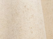 Nahaufnahme eines cremefarbenen Wollteppichs mit melierter Textur, seitliche Perspektive