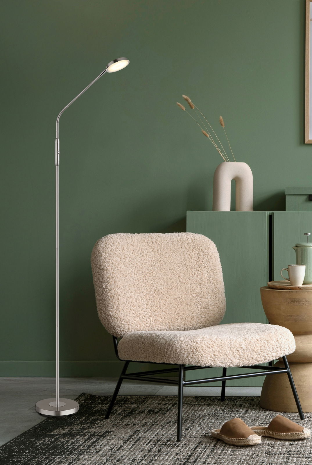 Moderne LED-Stehleuchte in einem stilvollen Wohnzimmer mit grünem Hintergrund, seitliche Perspektive