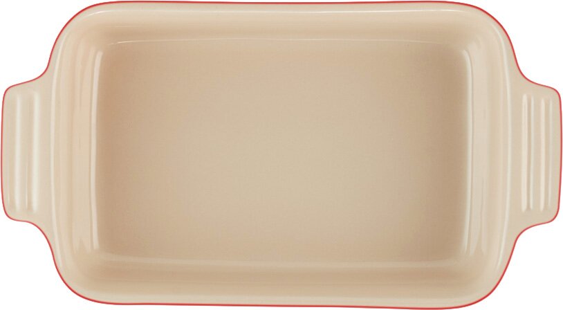 Bovenaanzicht van een rechthoekige beige ovenschaal met afgeronde hoeken, zijgrepen en een rode rand