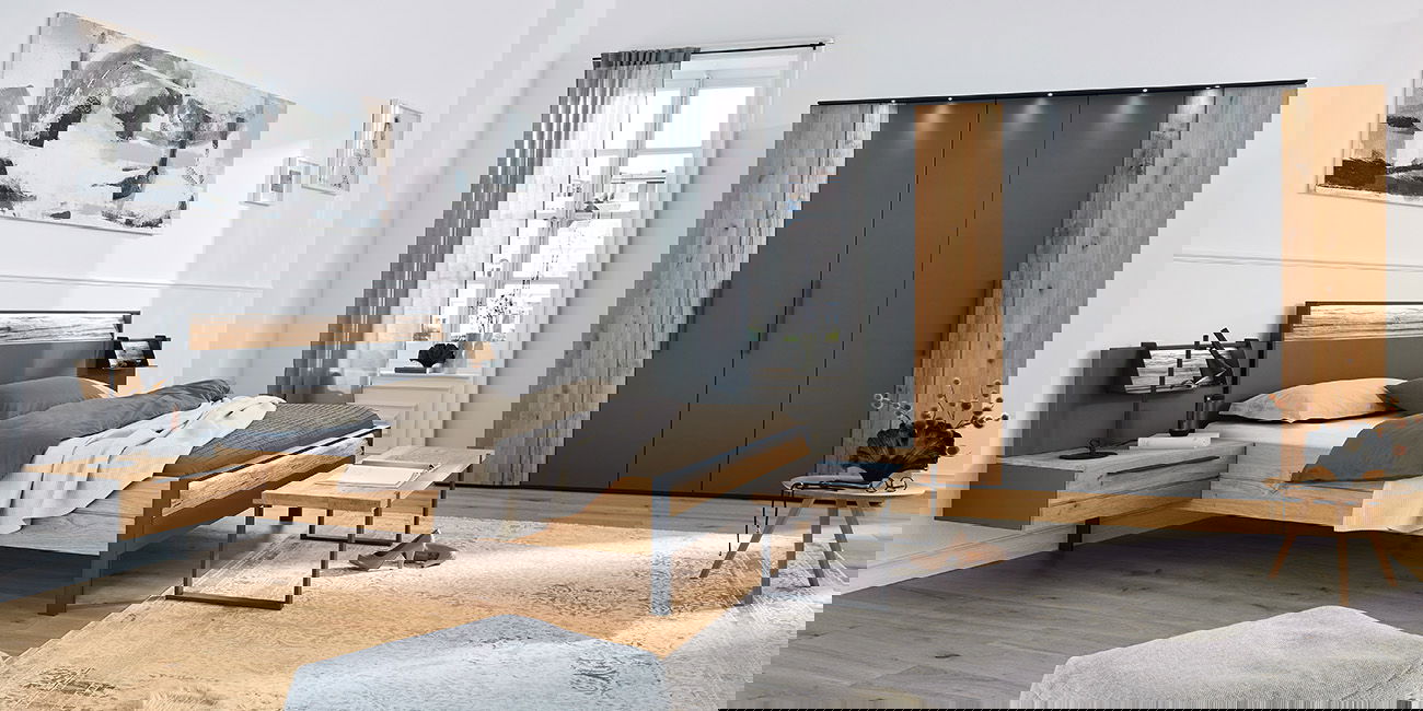 Modernes Schlafzimmer mit Holzbett, großem Schrank, Teppich und stilvollen Möbeln.