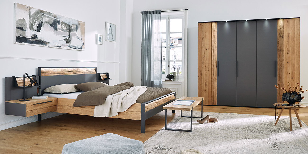 Modernes Schlafzimmer mit Holzbett, großem Schrank, Teppich und stilvollen Möbeln.