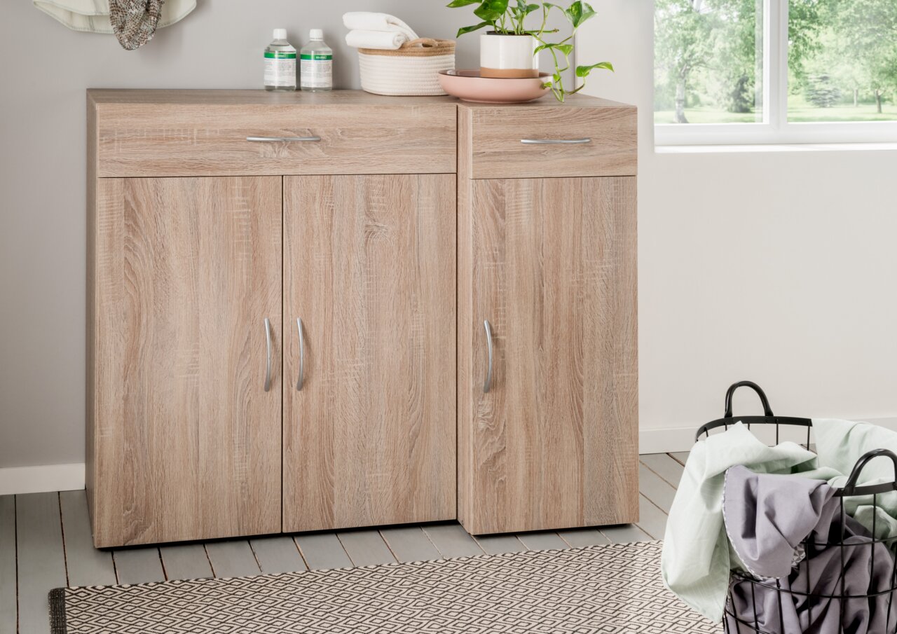 XORA Schuhschrank MULTIRAUMKONZEPT Moderner Schuhschrank aus Holz mit zwei Türen und Schubladen, frontal fotografiert, dekoriert mit Pflanzen und Handtüchern.