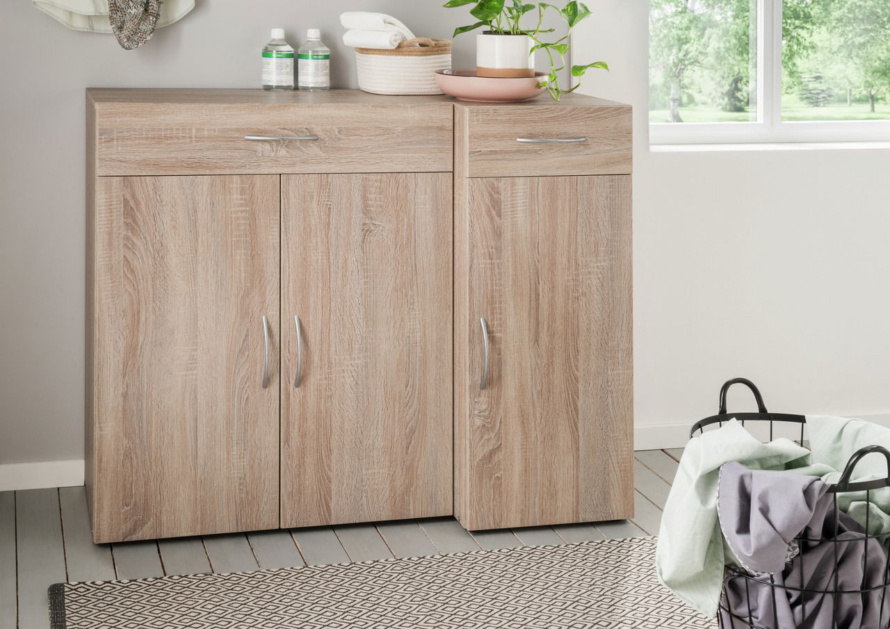 XORA Schuhschrank MULTIRAUMKONZEPT Moderner Schuhschrank aus Holz mit zwei Türen und Schubladen, frontal fotografiert, dekoriert mit Pflanzen und Handtüchern.