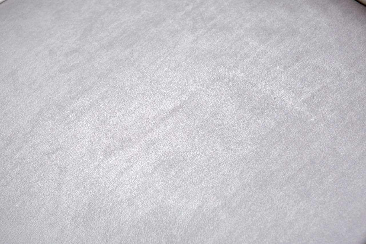 Nahaufnahme der grauen Stoffoberfläche eines Stuhlsitzes