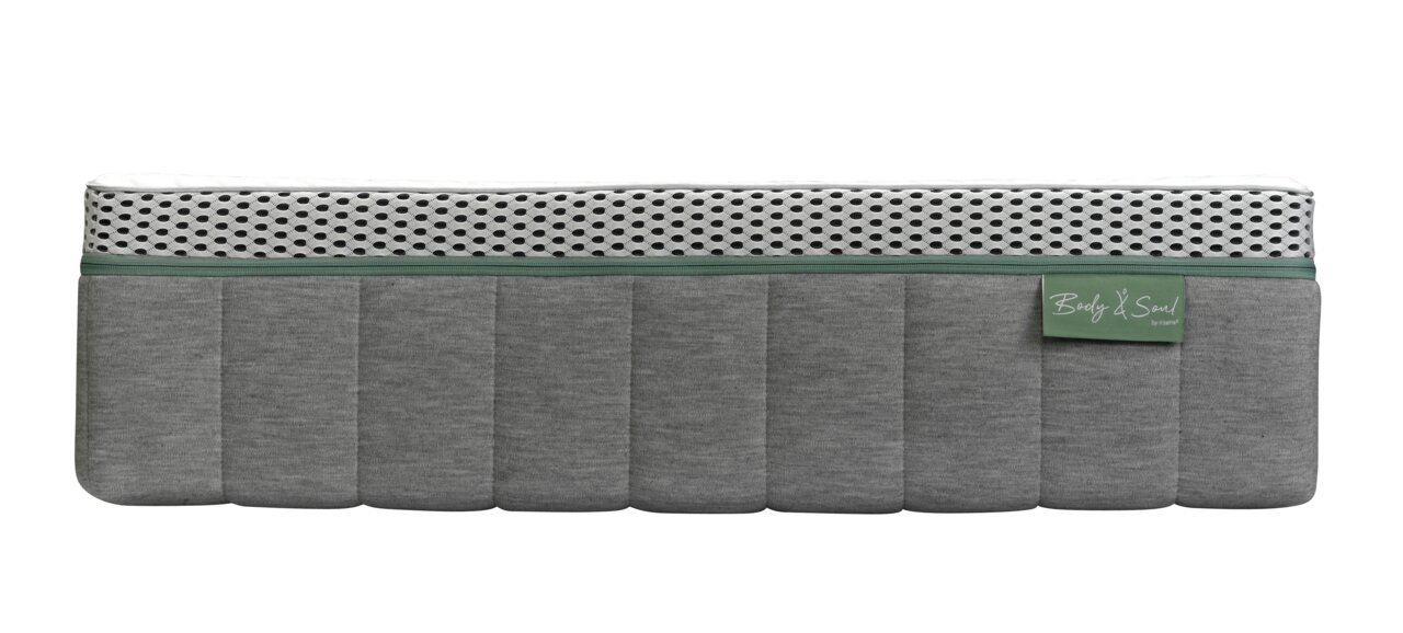 Seitenansicht einer grauen Matratze mit weißem, gepunktetem Oberteil und grünem Etikett.