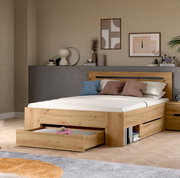 Modernes Holzbett in Eiche-Optik mit Kopfteil und ausziehbarem Bettkasten/Schublade, im Schlafzimmer-Setting; Perspektive: frontale 3/4-Ansicht von links auf das Bett.