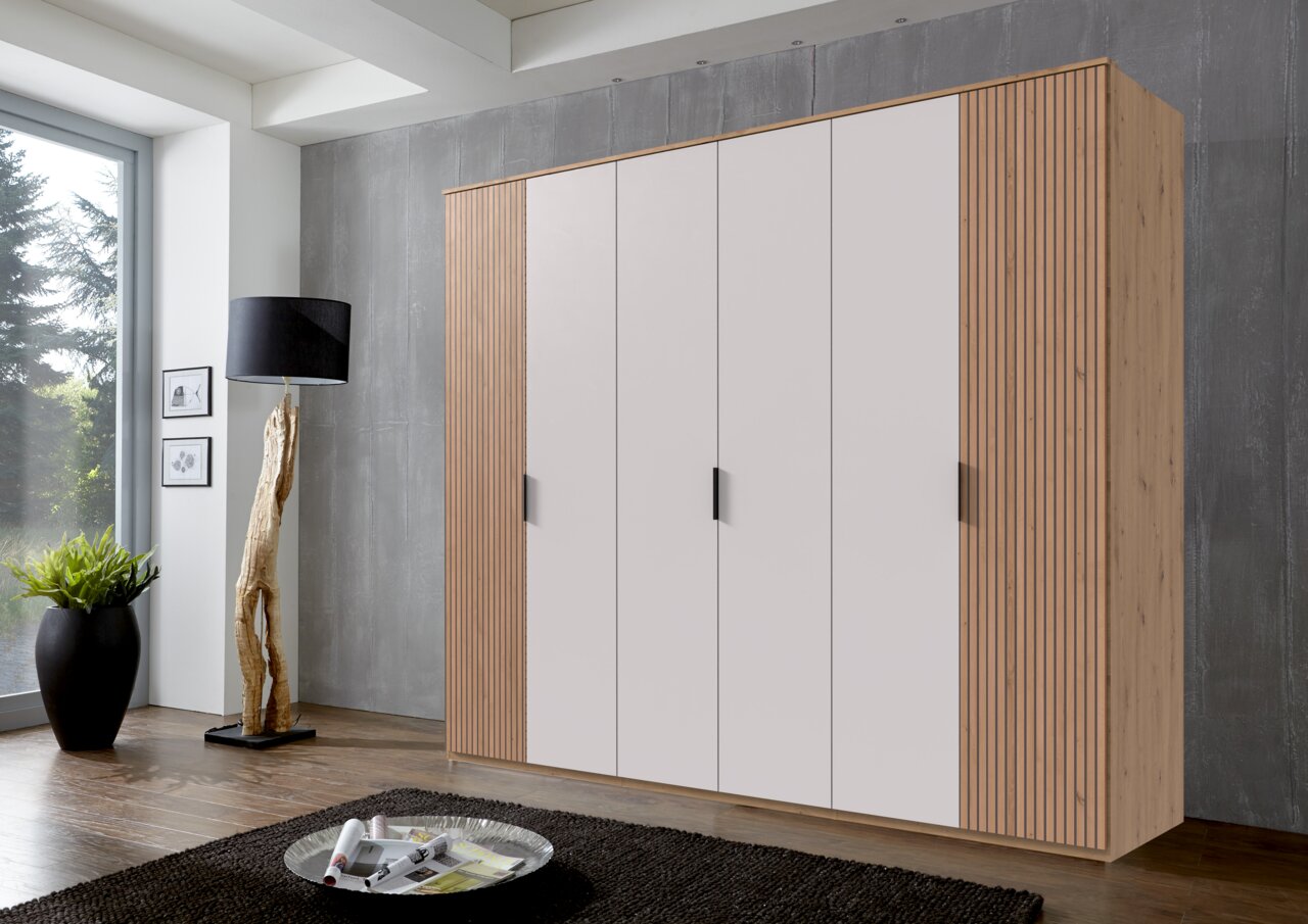 Kast met zes draaideuren in een modern ontwerp, van rechtsaf gefotografeerd, met witte deuren en houten zijkanten.