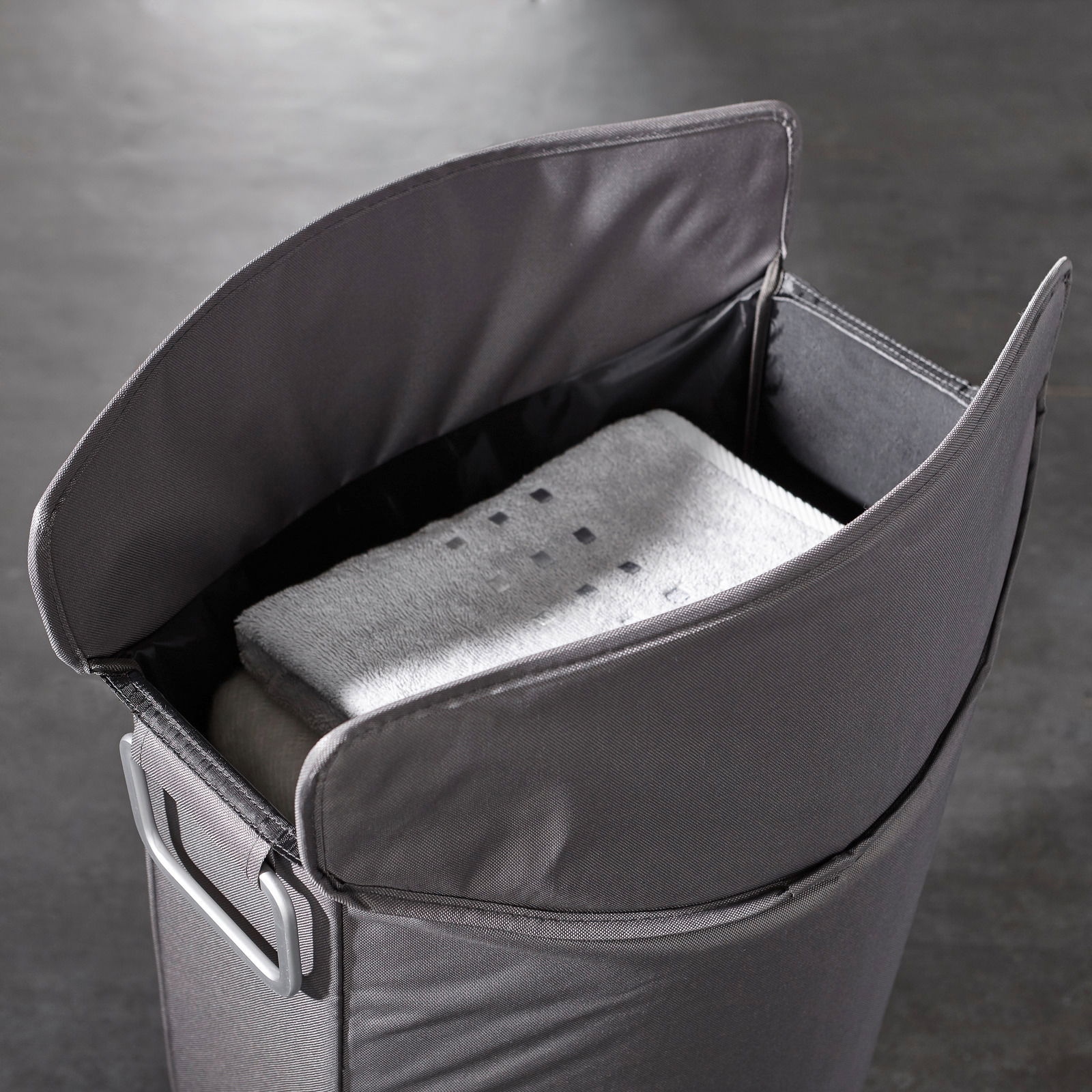 blomus Wäschesammler FRISCO Grauer Wäschesammler mit geöffnetem Deckel, gefüllt mit Handtüchern, aus der Vogelperspektive.