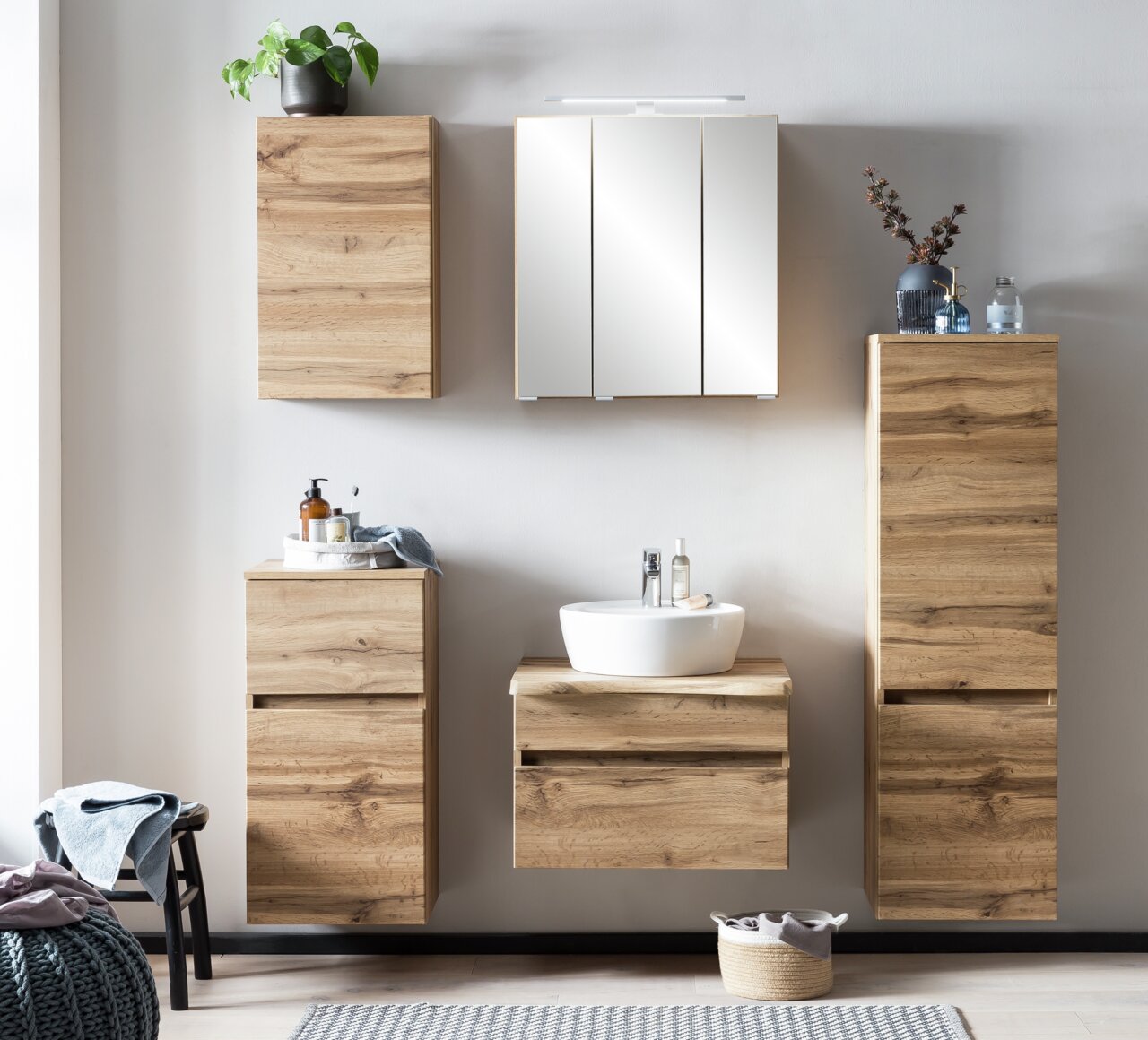 Moderner Spiegelschrank in einem stilvollen Badezimmer mit Holzschränken, Waschbecken und Dekorationen, Frontalansicht.