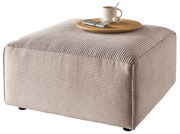 Beiger Hocker mit gerippter Oberfläche, darauf ein Tablett mit Tasse und Besteck, seitliche Perspektive