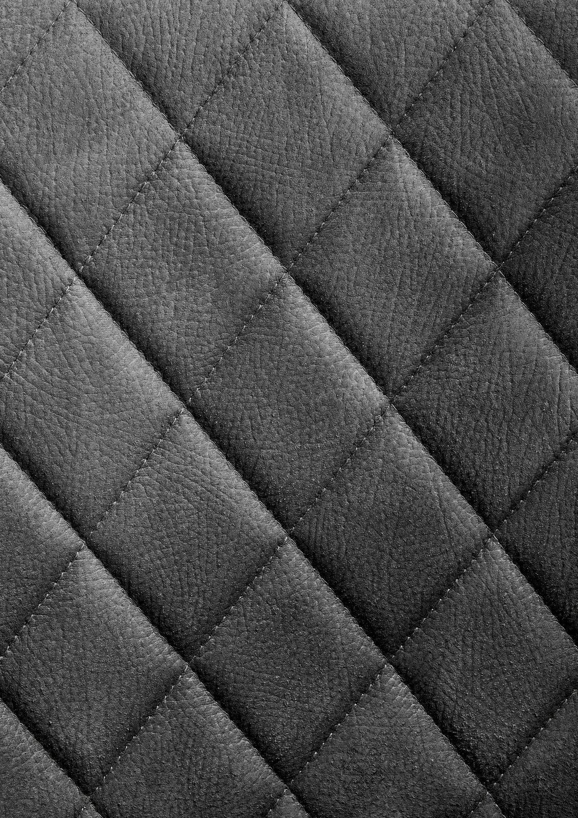 Nahaufnahme einer grauen, gesteppten Lederoberfläche in Rautenmuster.