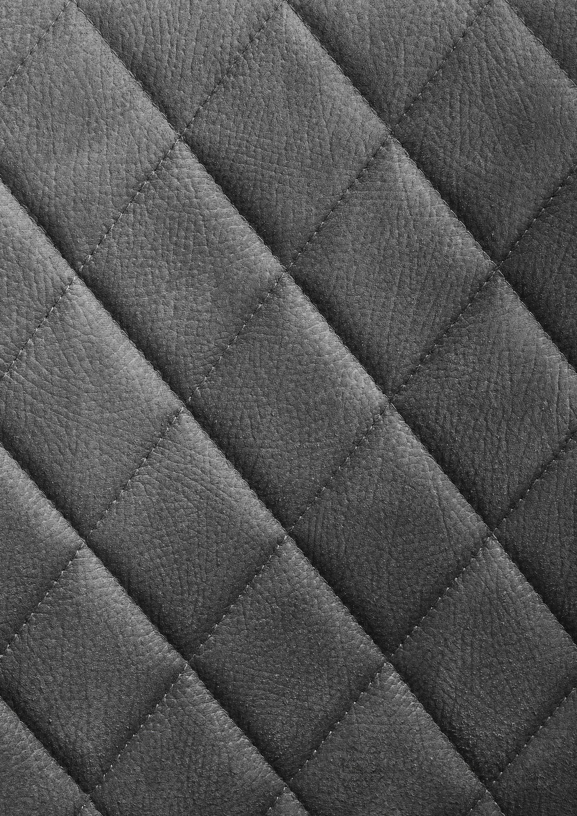 Nahaufnahme einer grauen, gesteppten Lederoberfläche in Rautenmuster.