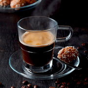 Espressotasse Senso 70ml aus Glas mit Untertasse, gefüllt mit heißem Espresso, seitliche Perspektive