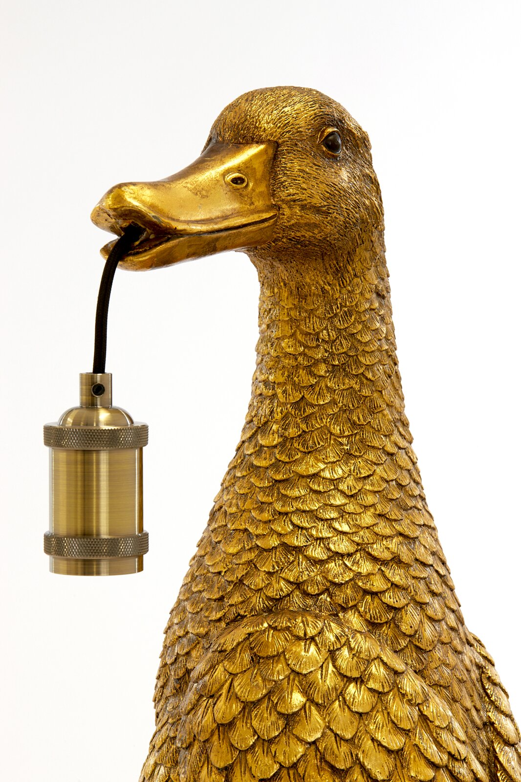 Goldene Tischleuchte in Form einer Ente, die eine Lampenfassung im Schnabel hält, seitliche Perspektive.