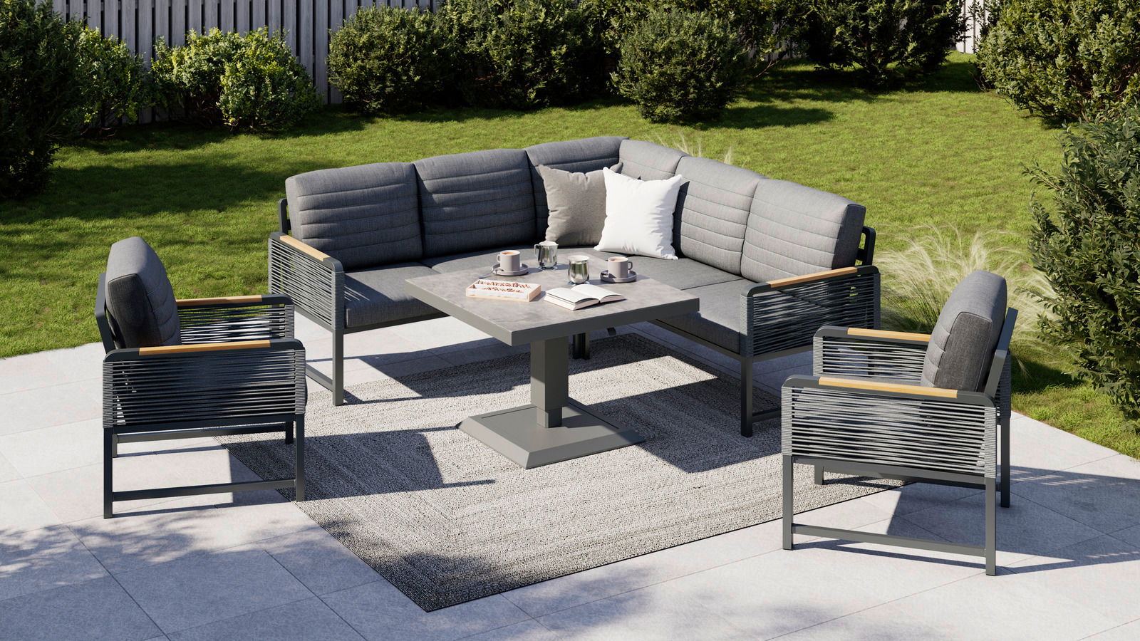 Moderne Loungegarnitur im Garten mit grauen Polstern, bestehend aus einem Ecksofa, einem Tisch und zwei Sesseln, aus der Vogelperspektive fotografiert.