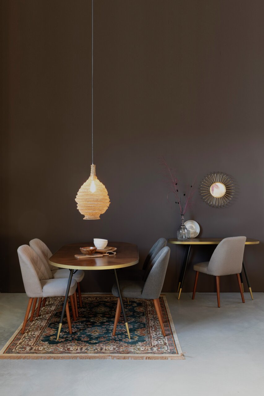 Moderner Esstisch mit vier Stühlen, dekoriert mit Geschirr und einer hängenden Lampe, aus der Frontalperspektive.