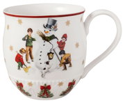 Henkelbecher mit Schneemann-Motiv, umgeben von spielenden Kindern und einem Hund, aus seitlicher Perspektive fotografiert.
