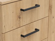 Nahaufnahme einer Kommode aus hellem Holz mit schwarzen Griffen, seitliche Perspektive